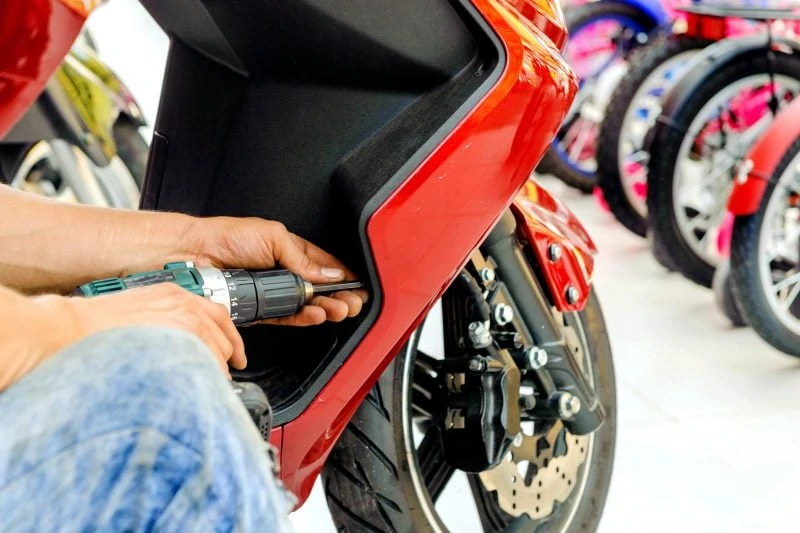 man repairing a scooter vespa like